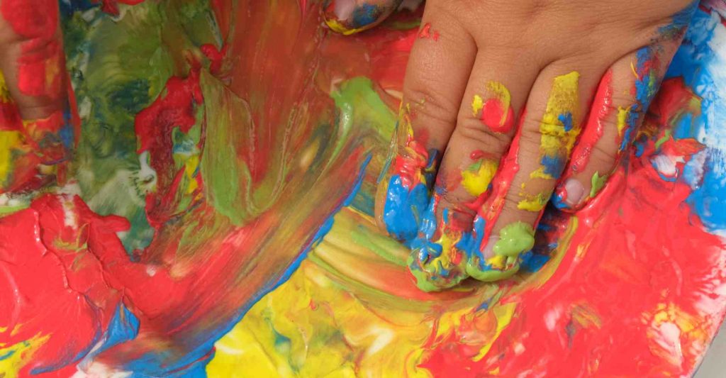 Child finger painting a common child development activity