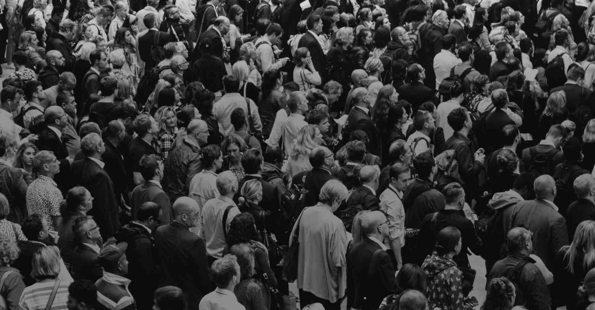 Diverse crowd of people walking close together.