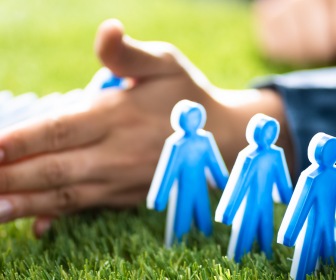 People represented as dominos. Hand preventing people from falling, representing a potential benefit of prevention data.