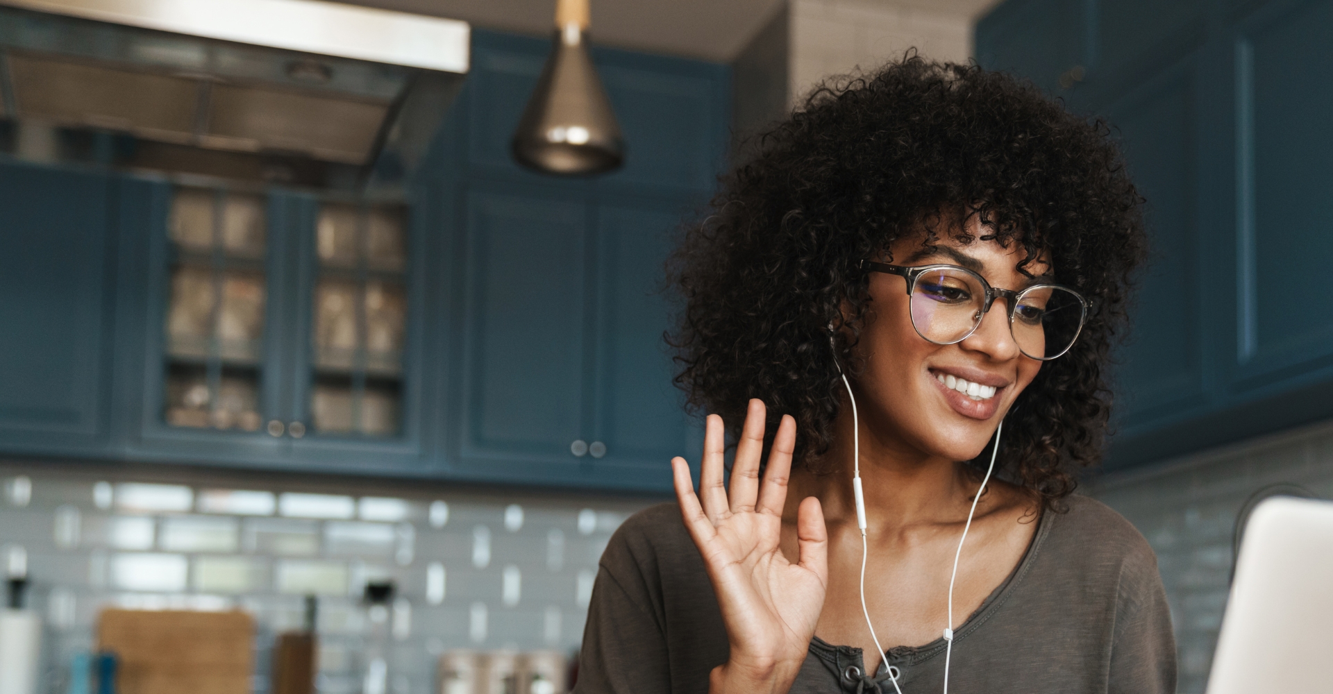 Black woman on a research video call waving to the person on the other end of the computer screen