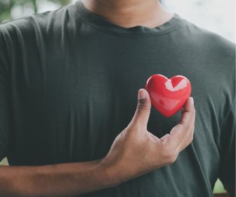 Heart health represented by man holding heart.