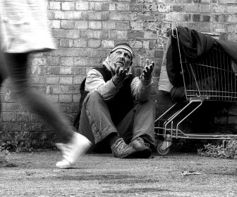 White man experiencing homelessness expressing his frustration toward someone who ignored him as they walked by.