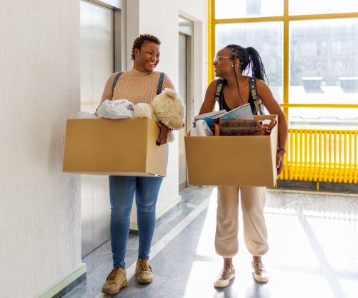 2 Black freshmen women college students moving into their dorms.