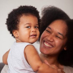 Black mom and baby laughing together.