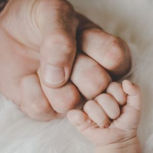 White dad and baby fist bumping.