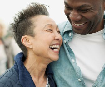 Asian woman and Black man laughing together